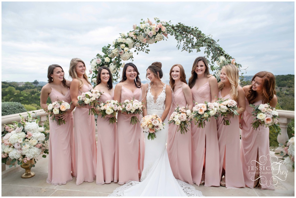 Bridesmaids wearing pink dresses hold bouquets by The Bloom Bar